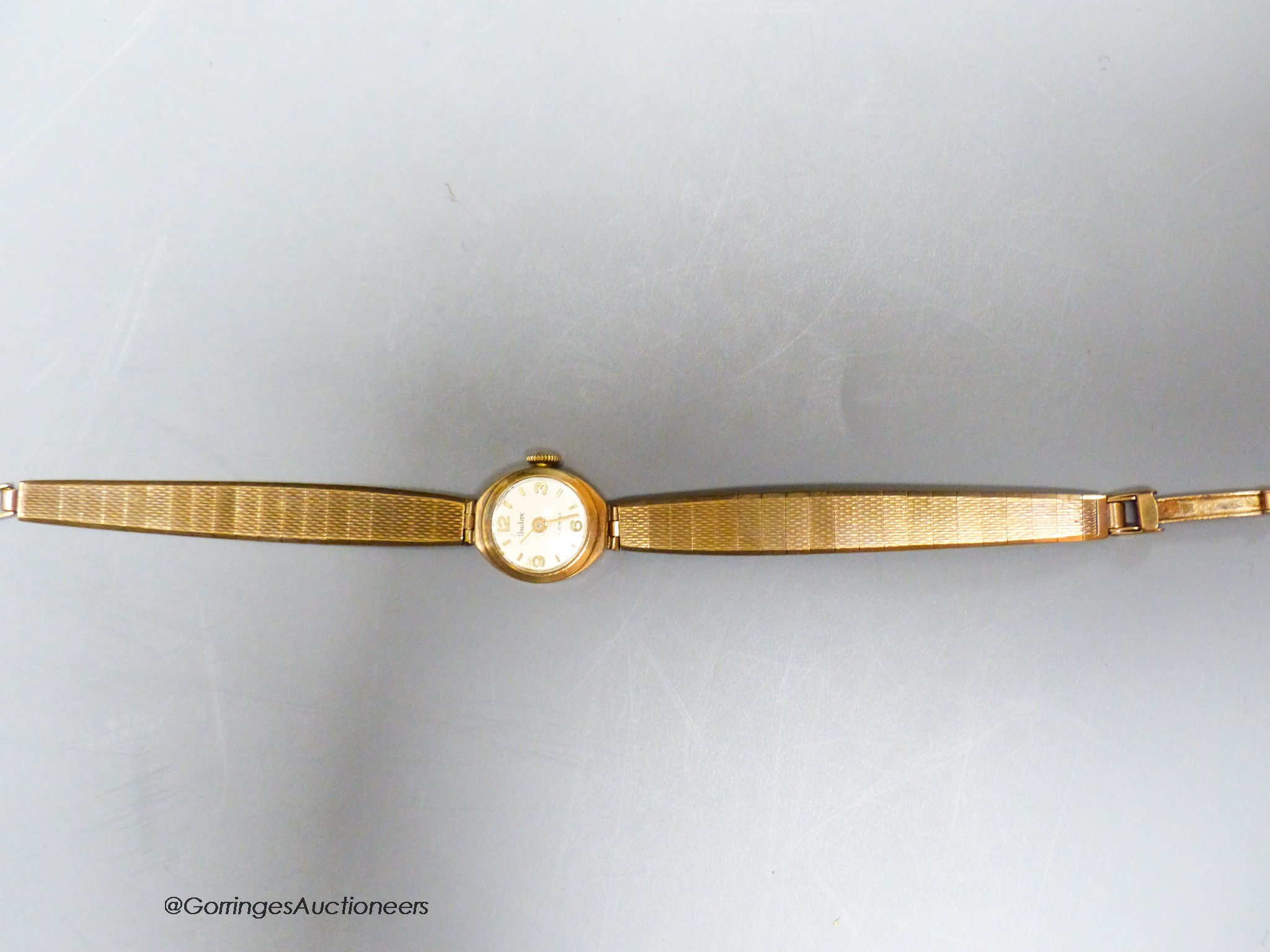 A lady's Audax 9ct gold manual wind wrist watch, on a 9ct gold bracelet